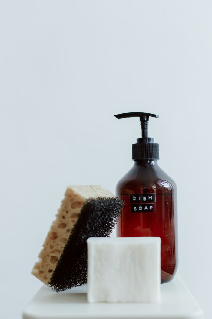 vision Aesthetic shot of dish soap, sponge, and soap bar on white backdrop.